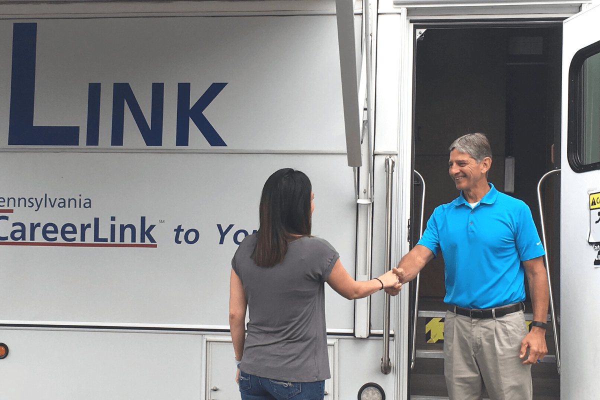 two adults shaking hands outside The Link mobile center