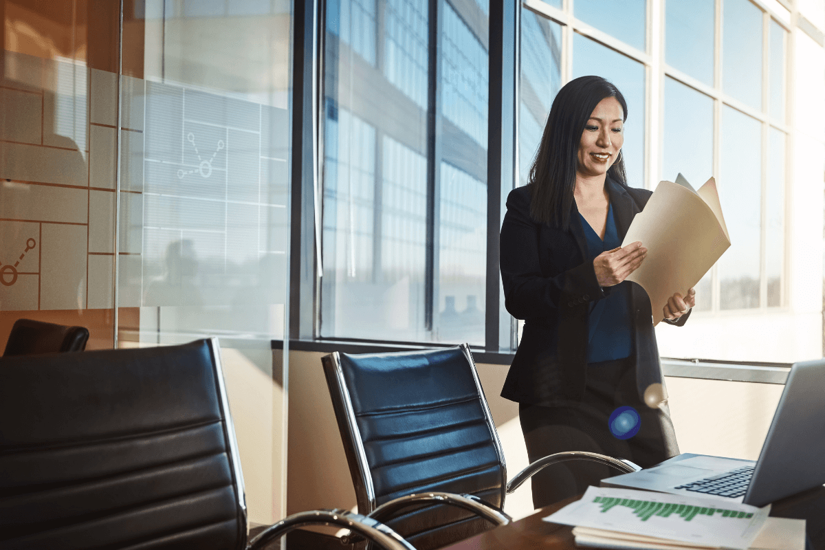 woman standing in an office holding a file folder