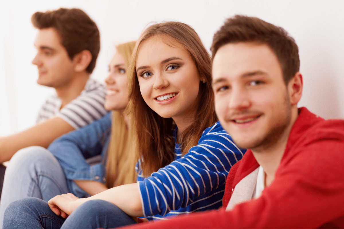 four young students sitting side by side