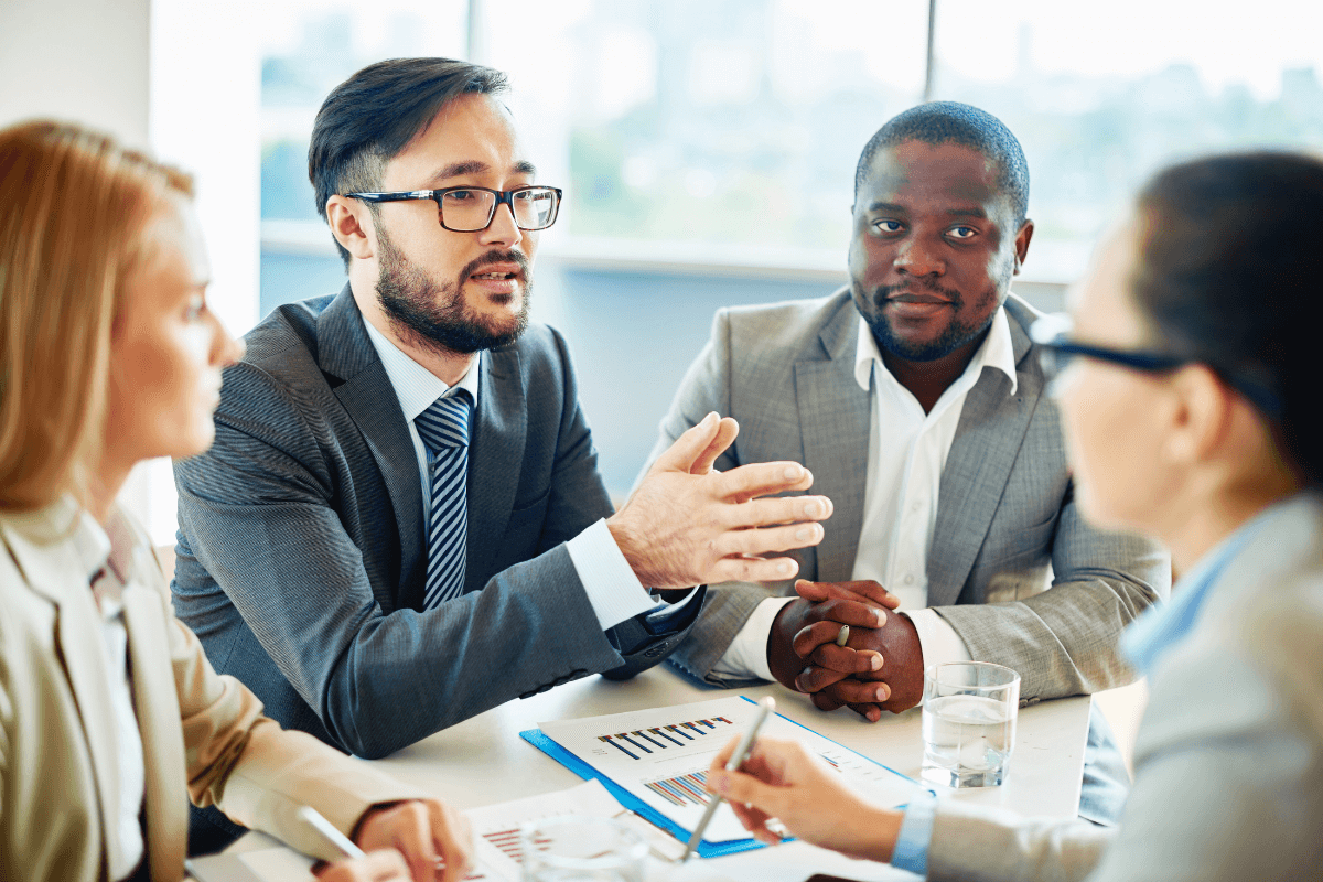 four diverse adults sitting around a table