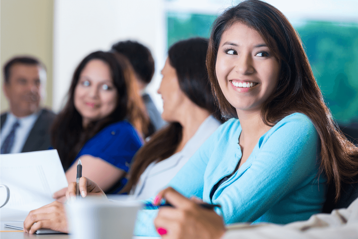 close up of smiling female employees sitting at a table